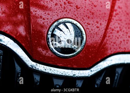München, Deutschland. August 2025. Das Markenlogo (Emblem, Herstellerlogo) und der Schriftzug des Autoherstellers Skoda sind am 28. August 2025 auf der regennassen Schnauze eines Fahrzeugs der Firma München (Bayern) zu sehen. Skoda Auto ist ein tschechischer Automobilhersteller aus der Tschechischen Republik und eine hundertprozentige Tochtergesellschaft der Muttergesellschaft Volkswagen AG. Quelle: Matthias Balk/dpa/Alamy Live News Stockfoto