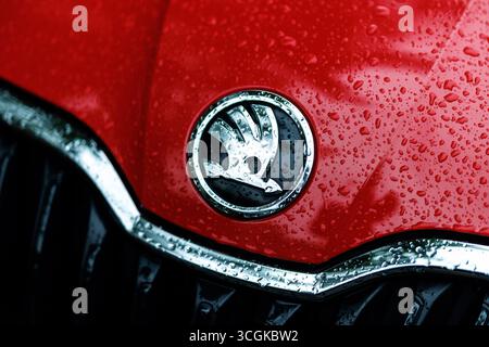 München, Deutschland. August 2025. Das Markenlogo (Emblem, Herstellerlogo) und der Schriftzug des Autoherstellers Skoda sind am 28. August 2025 auf der regennassen Schnauze eines Fahrzeugs der Firma München (Bayern) zu sehen. Skoda Auto ist ein tschechischer Automobilhersteller aus der Tschechischen Republik und eine hundertprozentige Tochtergesellschaft der Muttergesellschaft Volkswagen AG. Quelle: Matthias Balk/dpa/Alamy Live News Stockfoto