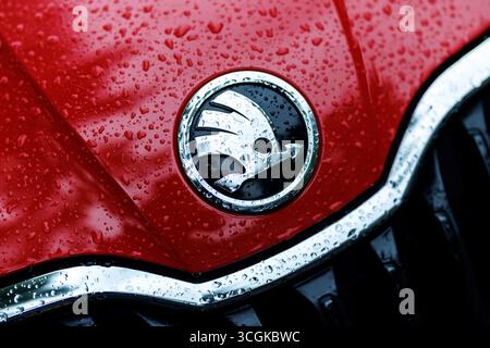 München, Deutschland. August 2025. Das Markenlogo (Emblem, Herstellerlogo) und der Schriftzug des Autoherstellers Skoda sind am 28. August 2025 auf der regennassen Schnauze eines Fahrzeugs der Firma München (Bayern) zu sehen. Skoda Auto ist ein tschechischer Automobilhersteller aus der Tschechischen Republik und eine hundertprozentige Tochtergesellschaft der Muttergesellschaft Volkswagen AG. Quelle: Matthias Balk/dpa/Alamy Live News Stockfoto