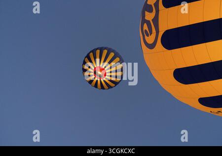 Zwei gelb-blaue Heißluftballons, die vor einem klaren blauen Himmel schwimmen, Goereme Nationalpark, Goereme Tarihi Milli ParkIJ, Nevsehir Province, nEVs Stockfoto