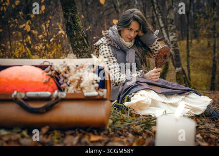 Eine Frau schaut in den Spiegel im Herbstwald Stockfoto