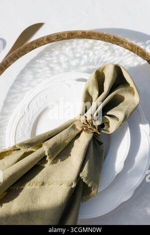 Eleganter Tisch mit einer schönen Serviettenfalte und einem einzigartigen Ring vor rustikaler Kulisse Stockfoto