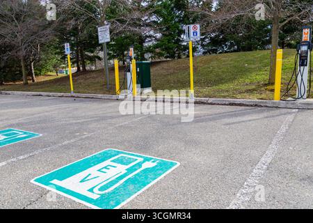 Ladestation für Elektrofahrzeuge auf dem Parkplatz. Ladestationen und Beschilderung auf Asphalt. Ontario, Kanada Stockfoto