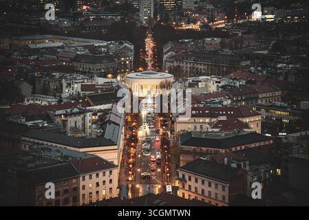 Aus der Vogelperspektive die beleuchtete Kuppel des Art Pavillons, die sich inmitten der Lichter der Stadt entlang einer von Bäumen gesäumten Straße erhebt, Zagreb, Kroatien. Stockfoto