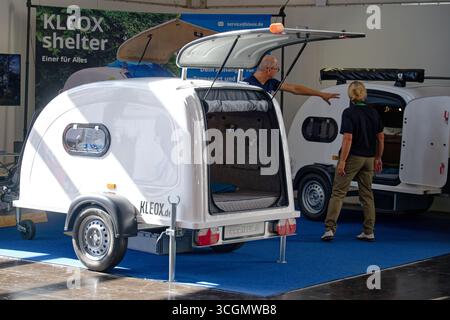 Düsseldorf, Deutschland. August 2025. Besucher des „Caravan Salon – Fachmesse für Caravaning, Camping und Outdoor-Tourismus“ sehen den Campinganhänger Shelter von Kleox. Bis Zum 7 . Im September werden mehr als 810 Aussteller in 15 Messehallen und auf dem Freigelände die Produkte und Dienstleistungen der Branche präsentieren. Quelle: Henning Kaiser/dpa/Alamy Live News Stockfoto