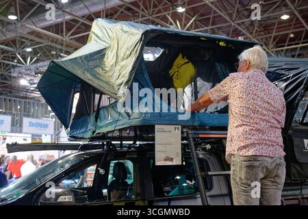 Düsseldorf, Deutschland. August 2025. Auf der „Caravan Salon – Fachmesse für Caravan, Camping und Outdoor-Tourismus“ sieht ein Besucher das Dachzelt „Vickywood Little Bamboo“ der Winch Instustry GmbH. Bis zum 7. September präsentieren mehr als 810 Aussteller in 15 Messehallen und auf dem Freigelände das Produkt- und Dienstleistungsangebot der Branche. Quelle: Henning Kaiser/dpa/Alamy Live News Stockfoto