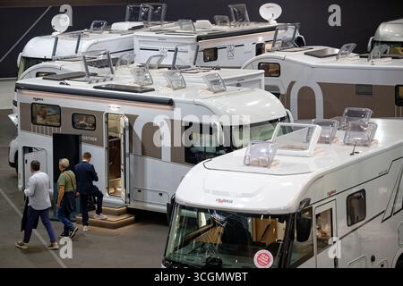 Düsseldorf, Deutschland. August 2025. Besucher gehen durch Hallen mit Mobilheimen auf der „Caravan Salon – Fachmesse für Caravaning, Camping und Outdoor-Tourismus“. Bis Zum 7 . Im September präsentieren mehr als 810 Aussteller in 15 Messehallen und auf dem Freigelände das Branchenangebot. Quelle: Henning Kaiser/dpa/Alamy Live News Stockfoto