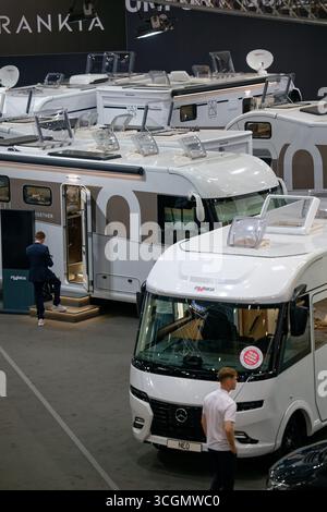 Düsseldorf, Deutschland. August 2025. Besucher gehen durch Hallen mit Mobilheimen auf der „Caravan Salon – Fachmesse für Caravaning, Camping und Outdoor-Tourismus“. Bis Zum 7 . Im September präsentieren mehr als 810 Aussteller in 15 Messehallen und auf dem Freigelände das Branchenangebot. Quelle: Henning Kaiser/dpa/Alamy Live News Stockfoto
