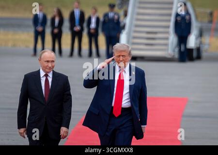 Anchorage, Vereinigte Staaten von Amerika. August 2025. US-Präsident Donald Trump, rechts, grüßt die Ehrenwache, als er den russischen Präsidenten Wladimir Putin begleitet, während der Ankunftszeremonie auf der Joint Base Elmendorf Richardson am 15. August in Anchorage, Alaska. Trump lädt Putin zu Gesprächen ein, um den russischen Krieg in der Ukraine zu beenden. Quelle: Justin Connaher/US Air Force Photo/Alamy Live News Stockfoto
