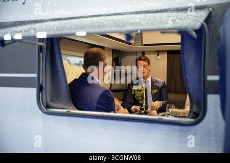 Düsseldorf, Deutschland. August 2025. Hendrik Wüst, Ministerpräsident Nordrhein-Westfalens (CDU), sitzt während eines Rundgangs durch den "Caravan Salon - Fachmesse für Caravaning, Camping und Outdoor-Tourismus" in einem Wohnwagen. Bis Zum 7 . Im September werden mehr als 810 Aussteller in 15 Messehallen und auf dem Freigelände die Produkte und Dienstleistungen der Branche präsentieren. Quelle: Henning Kaiser/dpa/Alamy Live News Stockfoto