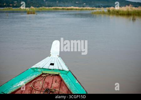 Traditionelles hölzernes Flussboot Bow Ayeyarwaddy Flussfahrt Mandalay Myanmar // MANDALAY, Myanmar – der Bogen eines traditionellen hölzernen Flussbootes wird aus einer Perspektive während einer Flussfahrt auf dem Ayeyarwady River dargestellt. Der Ayeyarwady (auch bekannt als Ayeyarwaddy oder Irrawaddy) ist Myanmars längster Fluss und seine wichtigste kommerzielle Wasserstraße. Mandalay liegt am östlichen Ufer des Ayeyarwady und ist ein bedeutender wirtschaftlicher und kultureller Mittelpunkt in Myanmar. Die Flussfahrt ist nach wie vor ein gängiges und wesentliches Transportmittel für Güter und Personen in der gesamten Region Mandalay und acros Stockfoto