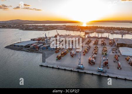 Aus der Vogelperspektive zum neuen Containerentladeterminal des Hafens von Burgas, Bulgarien bei Sonnenuntergang. Logistik und Transport Stockfoto