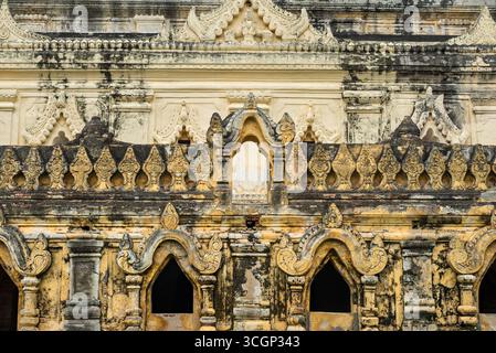 Maha Ant Htoo Kan Thar Pagode Stuckfassade Amarapura Myanmar // AMARAPURA, Myanmar - die komplizierte Stuckfassade der Maha Ant Htoo Kan Thar Pagode zeigt raffinierte traditionelle burmesische dekorative Motive. Dieses detaillierte Reliefwerk, das charakteristisch für die birmanische Tempelarchitektur ist, umfasst komplexe Muster und dekorative Elemente. Die Pagode ist eine bedeutende buddhistische Stätte in Amarapura. Amarapura, eine ehemalige königliche Hauptstadt, ist bekannt für ihr reiches kulturelles Erbe und zahlreiche buddhistische Stätten. Es liegt in der Region Sagaing in Myanmar (Birma). Stockfoto