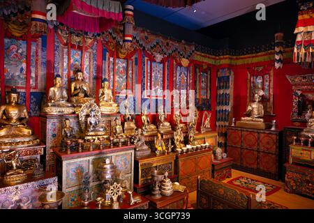 Smithsonian National Museum of Asian Art Tibetan Shrine Room Washington DC USA // WASHINGTON DC – der Tibetan Shrine Room im Smithsonian National Museum of Asian Art zeigt eine Reihe von vergoldeten Buddha-Statuen und traditionellen Ritualgegenständen. Diese permanente Installation bildet ein traditionelles tibetisch-buddhistisches Heiligtum nach und bietet ein immersives Erlebnis. Der mit Thangkas und bunten Textilien geschmückte Raum ist Teil der Freer Gallery of Art und der Arthur M. Sackler Gallery. Die Ausstellung, die das Museum bildet, wurde 2001 eröffnet. Es liegt an der National Mall. Stockfoto