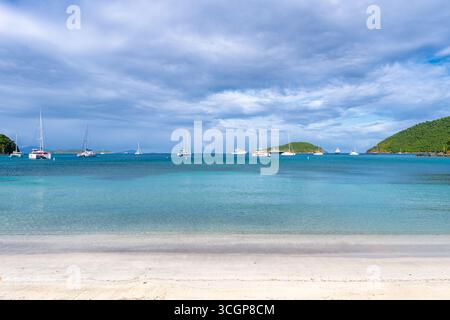 Segelboote und Yachten in Maho Bay St. John US Jungferninseln | ST. JOHN, US Jungferninseln — Segelboote und Katamarane liegen vor Anker im flachen, türkisfarbenen Wasser der Maho Bay, an der Nordküste des Virgin Islands National Parks. Das ruhige, sandige Wasser der Bucht und das ausgedehnte Seegrasfeld machen sie zu einem der zuverlässigsten Orte des Territoriums, um grüne Meeresschildkröten beim Fressen zu beobachten. Der Zugang von der Straße entlang der North Shore Road, etwa 5 Meilen (8 km) östlich von Cruz Bay, macht den Ankerplatz zu einem beliebten Zwischenstopp für Bootsführer. Stockfoto
