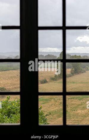 Blick durch Fenster auf die regnerische Landschaft Stockfoto
