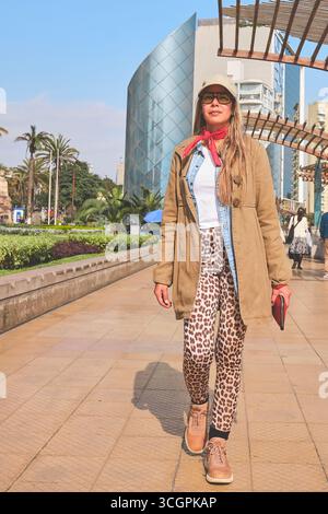 Touristen erkunden den kennedy Park in miraflores, lima, mit moderner Architektur im Hintergrund Stockfoto