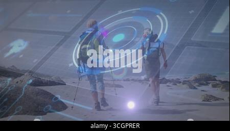 Wanderspaziergänge reife Wanderpaare überqueren die Sandküste mit Rucksäcken, Stiefeln, Stangen und AR-Karten Stockfoto