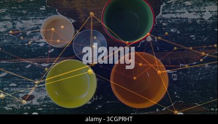 Schüsseln mit grüner Schüssel mit rotem Rand auf abgesplittertem grünem Tisch, mit goldenem Netzwerk überlagert Stockfoto
