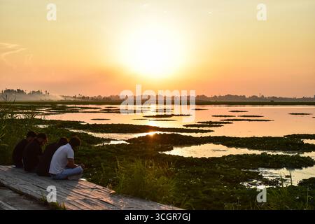 Die Bewohner ruhen sich während des Sonnenuntergangs am Ufer des Dal Sees aus, nachdem sich das Wetter über dem Jammu & Kaschmir verbessert hat. Die Verbesserung des Wetters in Jammu und Kaschmir hat den Menschen etwas Erleichterung gebracht, nachdem unaufhörliche Regenfälle und Wolkenbrüche eine Spur des Todes und der Zerstörung für Eigentum und Infrastruktur hinterlassen haben. Die Überschwemmungsgefahr in Kaschmir verringerte sich mit dem Rückgang der Wasserstände im Fluss Jhelum und anderen Gewässern. Der für die Abteilung zuständige Kommissar Kaschmir hat darauf hingewiesen, dass die nächsten 15 bis 20 Tage weiterhin kritisch bleiben, da die Monsunaktivität weiterhin andauert, obwohl der Wasserstand im Jhelum und seinen Nebenflüssen zu beobachten ist Stockfoto