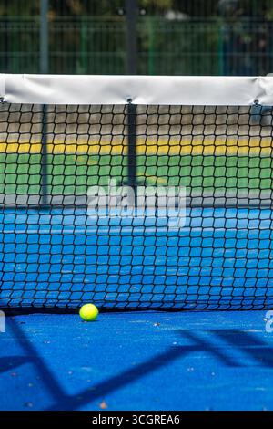 Paddeltennisball in der Nähe des Netzes auf einem blauen Paddeltennisplatz Stockfoto