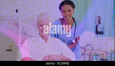 Leaning Nurse in Peelings, die den sitzenden Patienten im Krankenhauszimmer unterstützen, mit Stethoskop und Bettschienen Stockfoto
