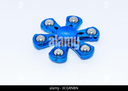 Glänzender blauer Metall zappeln Spinner mit Stahllagern auf weißem Hintergrund Stockfoto