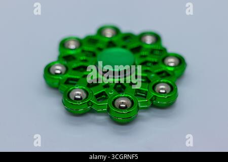 Glänzender grüner Metall zappeln Spinner mit Stahllagern auf weißem Hintergrund Stockfoto