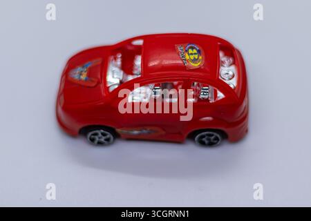 Kleines rotes Spielzeugauto im Bewegungsstil Stockfoto