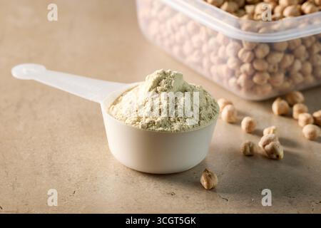 Eiweisspulver im Messlöffel. Erbsensportnahrung. Trockene Mischung zur Zubereitung von Sport- oder Diätgetränken. Stockfoto