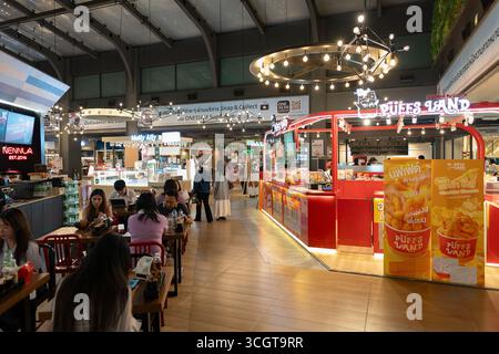 Bangkok, Thailand - 15. Oktober 2024: Innenaufnahme des Food Court im Einkaufszentrum Siam Center mit Imbissständen und Sitzbereichen. Stockfoto