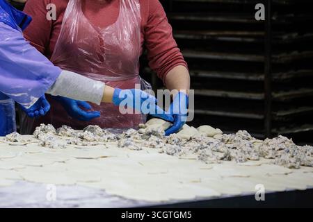 Bäcker kneten Teig und machen Kuchen in der Bäckerei Stockfoto