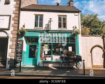Kilkenny Ireland, Juli 2023 Blaue Storefront mit einem Schild mit der Aufschrift „Hinds“. Der Laden ist geöffnet und hat ein Fahrrad draußen Stockfoto