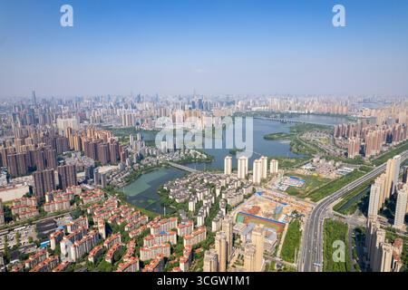 Der Blick auf die Stadt Wuhan China zeigt viele Gebäude und einen großen See unter klarem Himmel. Stockfoto