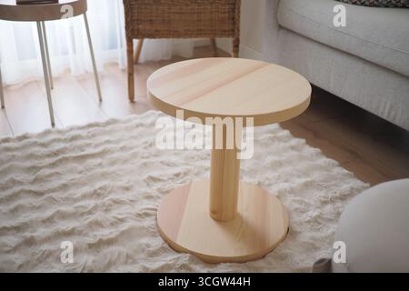 Moderner hölzerner Couchtisch in gemütlicher Wohnzimmeratmosphäre Stockfoto