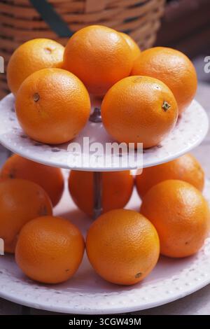Orangen sind ordentlich auf einem mehrstufigen Ausstellungsständer angeordnet Stockfoto
