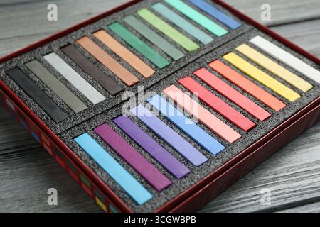 Bunte Kreidepastelltöne in Box auf Holztisch, Nahaufnahme Stockfoto