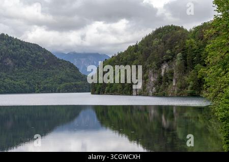 SCHWANGAU, DEUTSCHLAND - 23. MAI 2024: Dies ist ein Blick auf den Alpsee an einem bewölkten Frühlingstag. Stockfoto