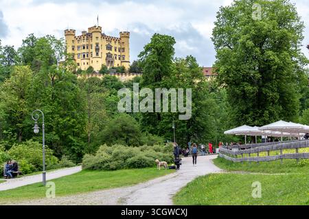 SCHWANGAU, DEUTSCHLAND - 23. MAI 2024: Von der Promenade entlang des Alpsees aus blickt man auf die Burg Hohenschwangau. Stockfoto