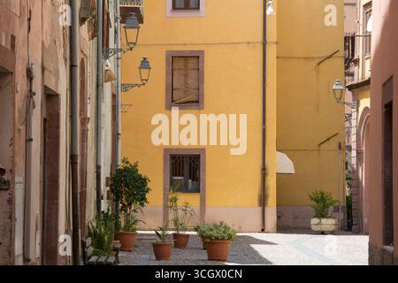 Bosa, Oristano, Sardinien, Italien. Eine farbenfrohe Ecke des historischen Stadtteils Sa Costa mit Topfpflanzen auf Kopfsteinpflaster. Stockfoto