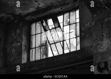 Zersplitterte und zerbrochene Glasfenster eines verlassenen Industriegebäudes. Stara Hala - altes Industriegebäude in Vysocany, Prag. Stockfoto