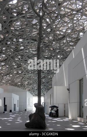 VAE - Abu Dhabi - Louvre Abu Dhabi Courtyard - verströmter Lichtregen unter der riesigen Kuppel über ruhige weiße Pavillons Stockfoto