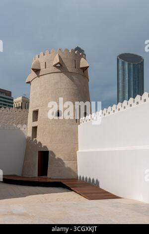 VAE - Abu Dhabi - Qasr Al Hosn Bastion - abgerundeter Turm und Stadtmauern, die zu schattigen Gassen innerhalb des historischen Komplexes führen Stockfoto