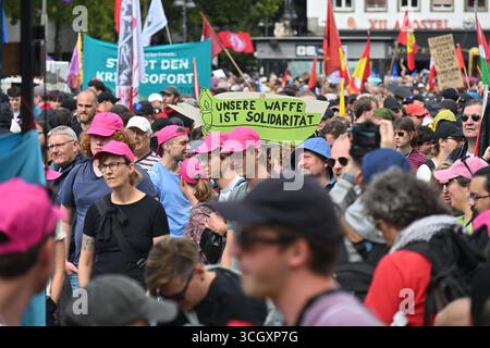 Köln, Deutschland. 30. August 2025. Demonstranten halten ein Poster mit dem Motto "unsere Waffe ist Solidarität" während eines Protestes, der von der Allianz "Entwaffnung Rheinmetall" organisiert wird. Das Kerngeschäft von Rheinmetall besteht derzeit aus Artillerie, Panzern, Munition und Flugabwehrkanonen. Deutschlands größtes Rüstungsunternehmen wächst infolge des Krieges in der Ukraine stark. Quelle: Henning Kaiser/dpa/Alamy Live News Stockfoto