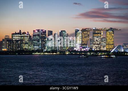 Blick vom Meer auf die Küste von nächtlichem Singapur. Stockfoto