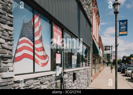 Großes Wandgemälde mit amerikanischer Flagge in einem Fenster eines Backsteingebäudes in Clio Michigan, USA Stockfoto