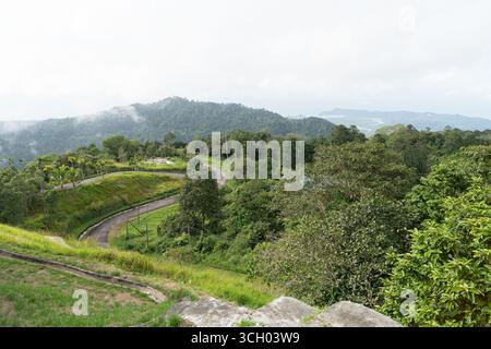 Langkawi, Malaysia - 11. September 2024: Eine kurvige, kurvige Straße, die durch grüne Hügel auf Langkawi führt. Stockfoto