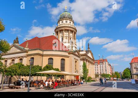 Berlin, Deutschland - 16. August 2025: Historischer deutscher Dom mit kunstvoller Architektur, Sitzgelegenheiten im Freien und leuchtendem blauem Himmel in Berlin. Stockfoto