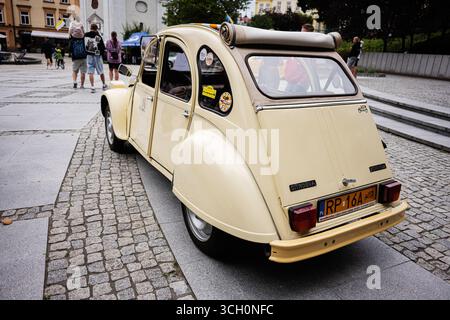 Przemysl, Polen - 23. August 2025: Vintage Citroen 2CV auf der Kopfsteinpflasterstraße in Przemysl, besucht von Touristen. Stockfoto