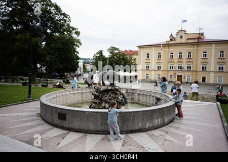 Przemysl, Polen - 23. August 2025: Öffentlicher Park mit Bärenbrunnen und historischen Gebäuden in Przemysl, Polen Stockfoto